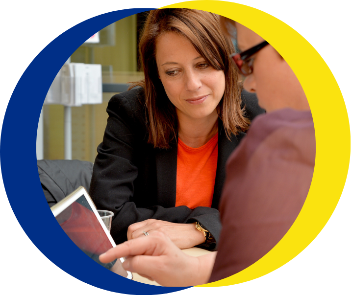 Two people look at a computer tablet