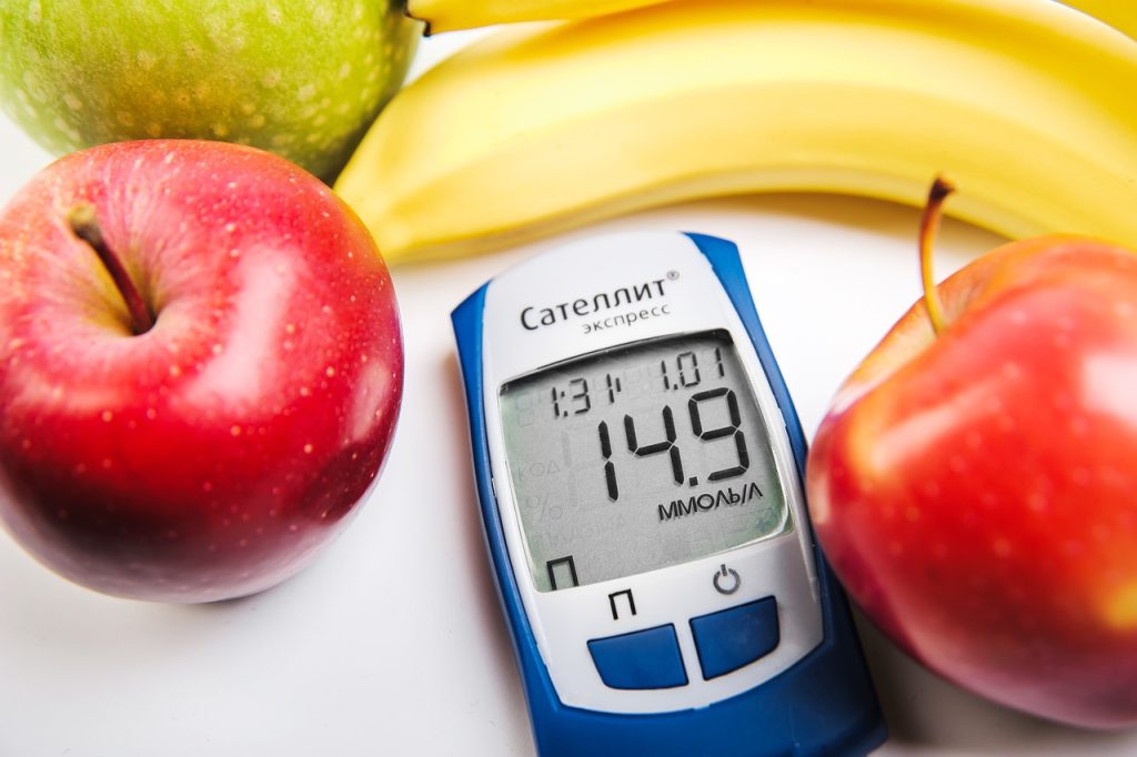 A picture of a blood sugar monitor with fruit