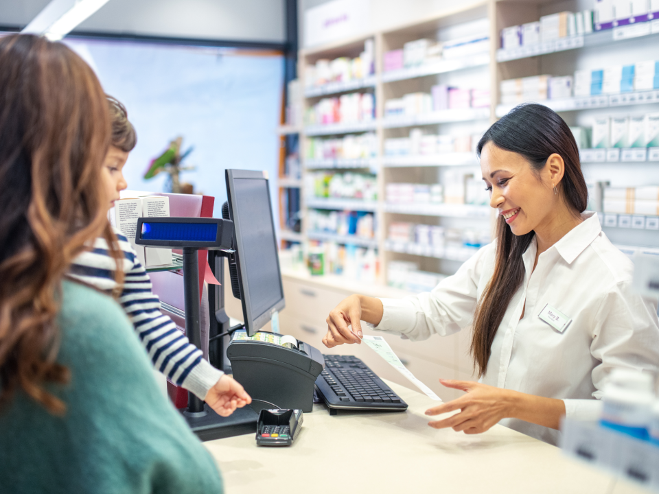 Pharmacist provides a prescription to a parent and child