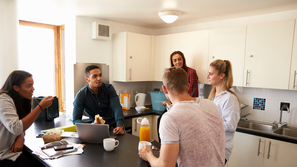 A group of students gathered together in a halls of residence kitchen.